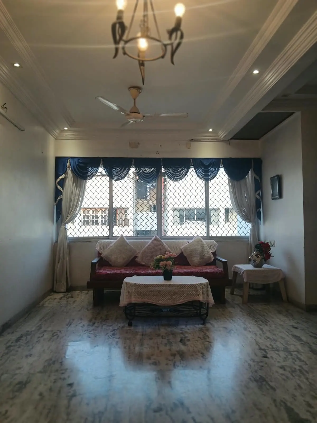 Living room with sofa, chandelier and false ceiling in a furnished 3 BHK flat at Sejal Apartment, City Light, Surat