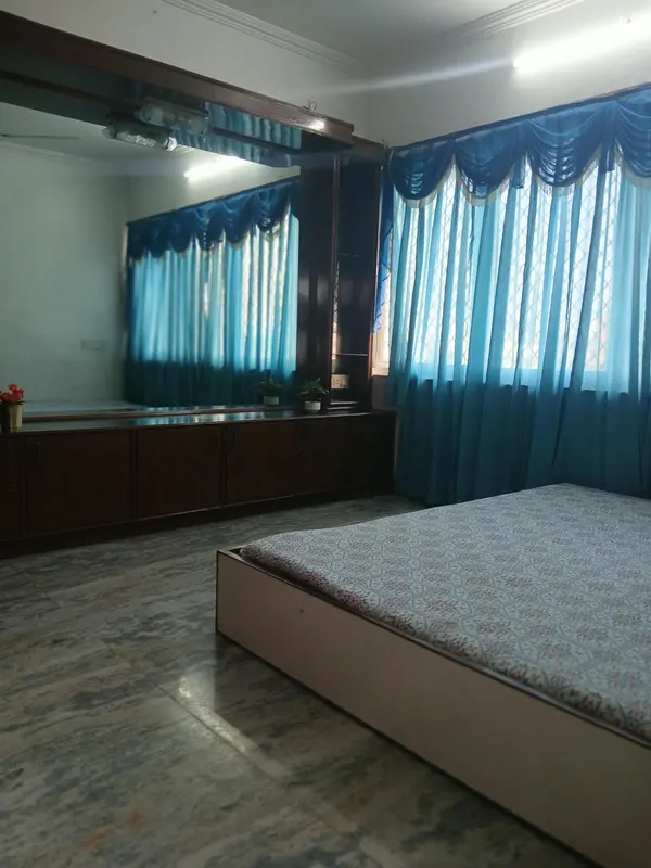 Master bedroom with blue curtains, large mirror and storage, City Light, Surat